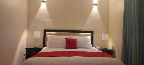 MacutoHotel Eduards Suite的一间卧室配有一张红色枕头的床