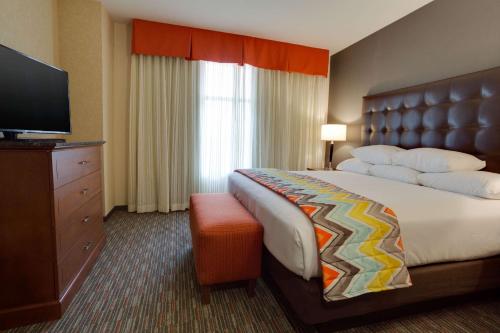 夏洛特夏洛特阿罗伍得套房德鲁酒店的配有一张床和一台平面电视的酒店客房