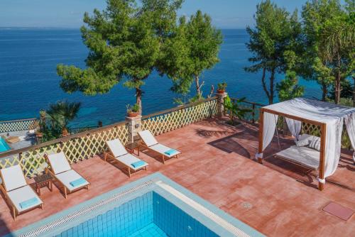 瓦西里科斯扎金索斯别墅的一个带桌椅的海洋游泳池