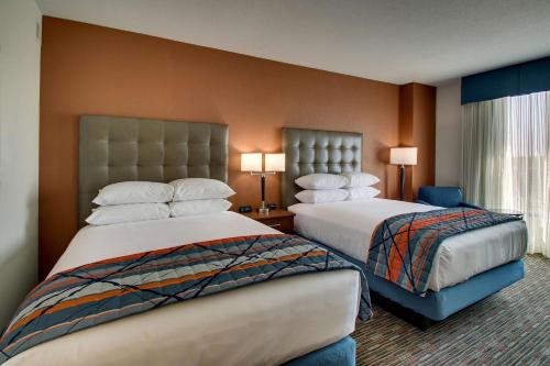克拉尔维尔Drury Inn & Suites Iowa City Coralville的酒店客房设有两张床和窗户。