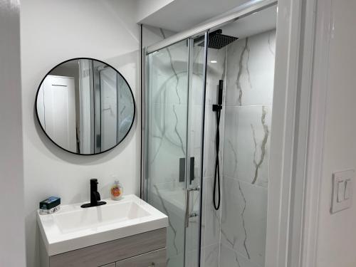 列治文山Cozy, brand-new, 2BDR,walkout apt, free parking的带淋浴、盥洗盆和镜子的浴室