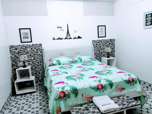 伊基托斯斯泰勒斯酒店的一间卧室配有一张带花卉棉被的床