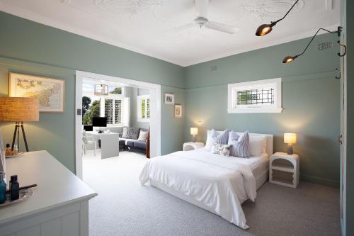 悉尼Modern Muse, Bellevue Hill的卧室配有白色床和蓝色的墙壁