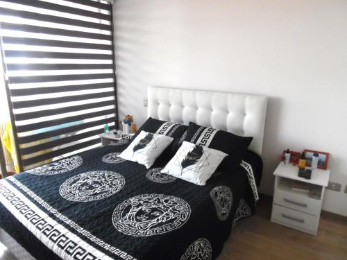 安托法加斯塔hermoso departamento con vista al mar的卧室配有带枕头的黑白床。