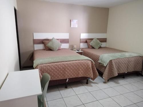 危地马拉Urban Home的酒店客房设有两张床和一张桌子。