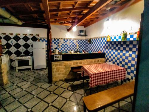 伦索伊斯Chapadão Hostel的厨房配有桌子、炉灶和冰箱。