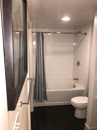 普莱诺Comfy and Cozy Legacy West Apartment steps from everything的浴室配有白色浴缸和卫生间。