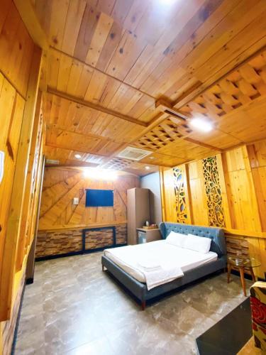 芹苴Hang Chau Hotel的木制客房内的一间卧室,配有一张床