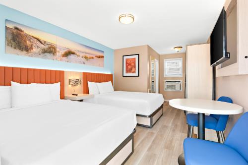 怀尔德伍德芒果汽车旅馆的酒店客房设有两张床和一张桌子。