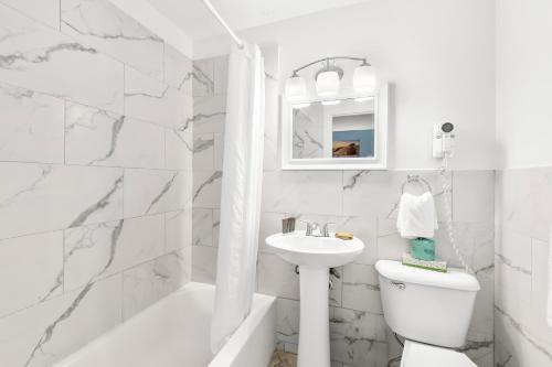 怀尔德伍德芒果汽车旅馆的白色的浴室设有水槽和卫生间。