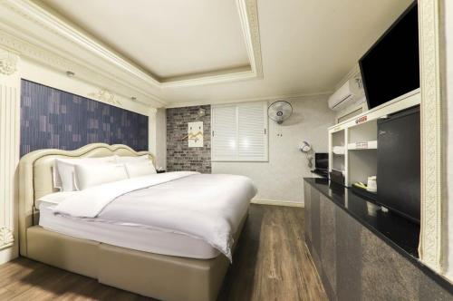 Sin-niNobless Motel的一间卧室配有一张大床和电视