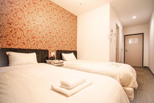 Kinugasaアナザースカイ京都二条城的两张位于酒店客房的床,配有毛巾