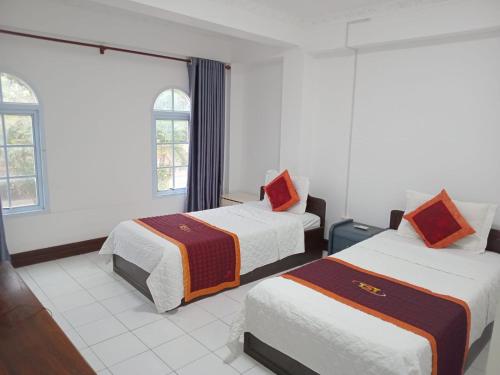 万象CHALEUNXAY hotel 赞乐大酒店的酒店客房带两张床和两个窗户