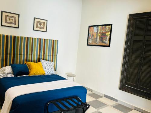 杜兰戈Hotel Boutique Casona los Pavorreales的一间卧室配有蓝色和黄色枕头的床