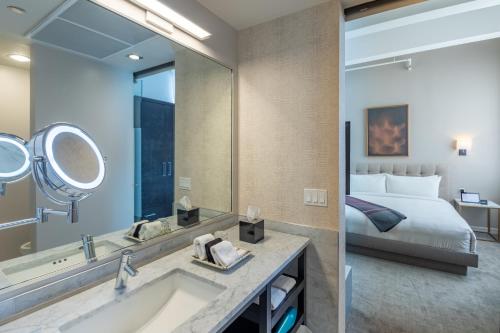 埃尔帕索Stanton House El Paso的一间带水槽和镜子的浴室以及一张床