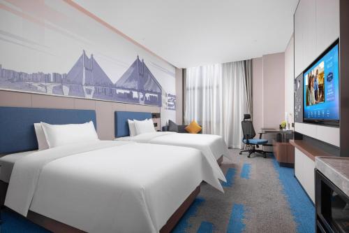 武汉Hampton by Hilton Wuhan Zhongnan Jiedaokou Hotel的酒店客房设有两张床和一台平面电视。
