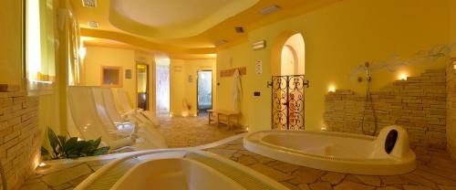 梅扎纳Hotel Dalla Serra的带浴缸和盥洗盆的大浴室