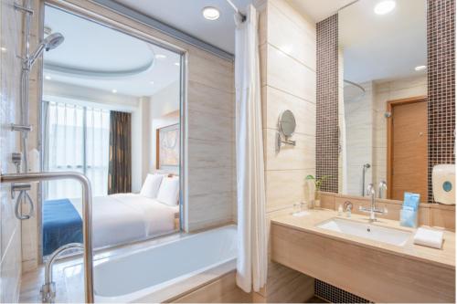 北京望京华彩北京智选假日酒店的带浴缸、水槽和床的浴室