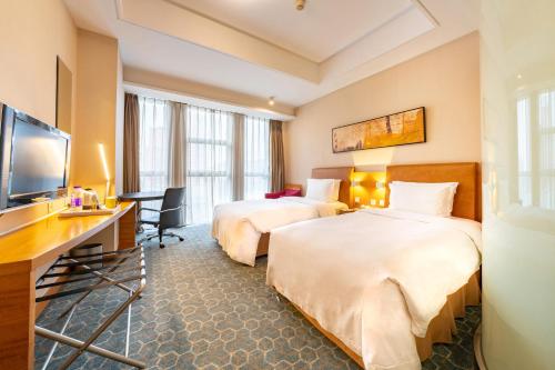 北京望京华彩北京智选假日酒店的酒店客房设有两张床和一台平面电视。