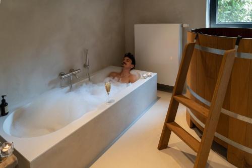 布兰肯贝赫Sauna-Garden的男人在泡泡的浴缸里