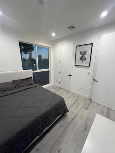 洛杉矶1BR Hollywood Townhouse的一间卧室设有一张床和两个窗户。