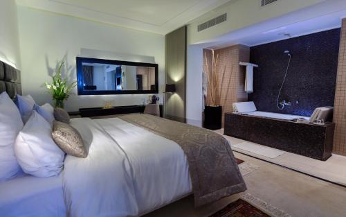 突尼斯商务酒店的酒店客房配有一张床和浴缸。