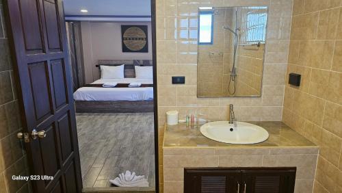 清莱Central Guesthouse Bread & Breakfast的一间带水槽和淋浴的浴室以及一张床