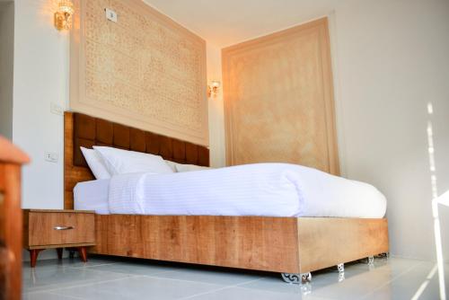 Al Ḩayy小佩特拉贝德营地旅馆的一间卧室配有一张带木制床头板的床