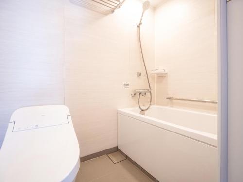 仓敷仓敷船舶酒店的白色的浴室设有浴缸和卫生间。