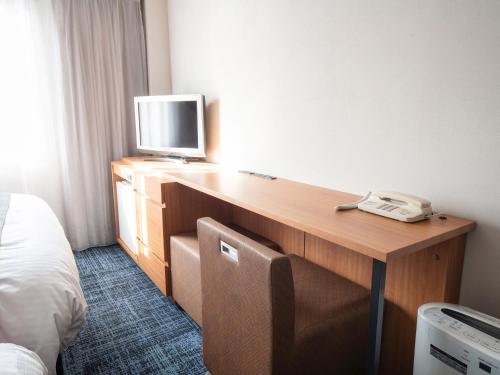 仓敷仓敷船舶酒店的酒店客房配有书桌、电视和电话