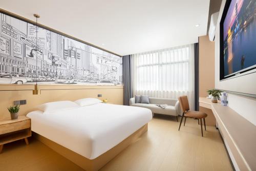婺源美颂·MISONG轻居设计酒店（上饶婺源景观桥店）的卧室配有一张白色的大床和一张沙发。