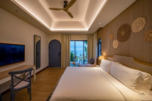 美奈Centara Mirage Resort Mui Ne的一间卧室配有一张大床和吊扇
