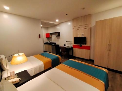 马尼拉Studio 89 Katipunan QC的酒店客房带两张床和厨房