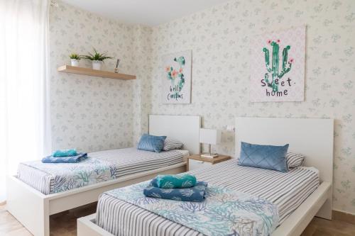 马贝拉AB Properties - Chic House Marbella - 3 mm to Puerto Banús and Beach - Golden Mile - Direct access to Pool and Tropical Garden的一间卧室配有两张带蓝色枕头的床。