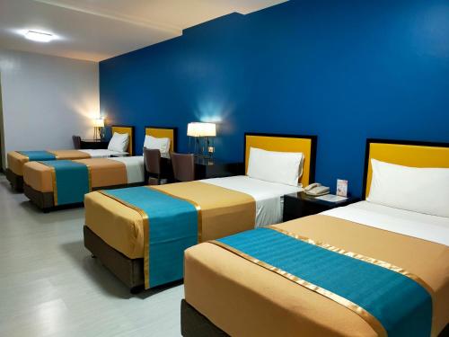 马尼拉Studio 89 Katipunan QC的蓝色墙壁的房间里设有三张床