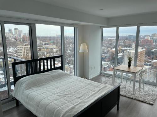 多伦多Toronto Premier INN的卧室配有床、桌子和窗户。