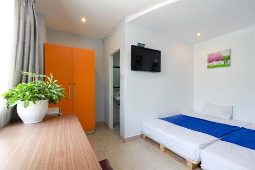 胡志明市Ehome Saigon - Gạo hostel的卧室配有一张床,墙上配有电视。