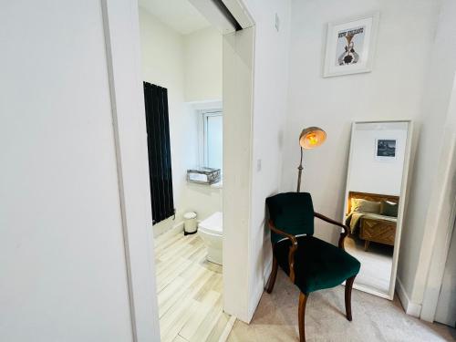 巴里Leah Suite by Koya Homes的带绿色椅子的客房和浴室