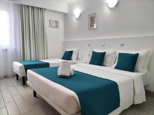普拉亚达巴拉Residencial Tropicália AL的蓝色和白色的客房内的两张床
