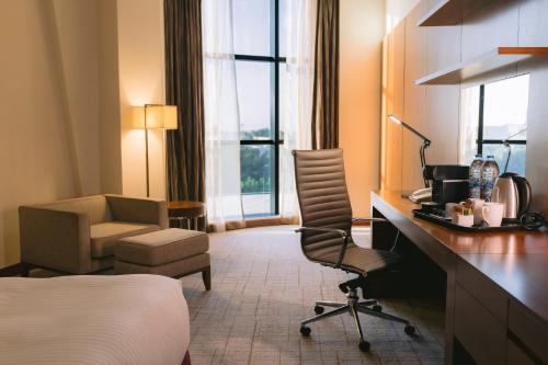 阿布扎比阿布扎比假日酒店的酒店客房配有一张床、一张桌子和一把椅子。