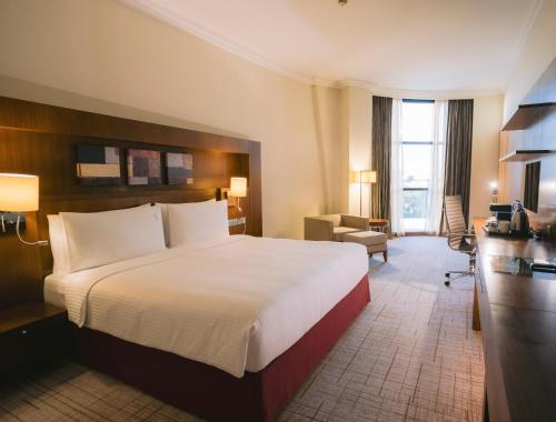 阿布扎比阿布扎比假日酒店的酒店客房设有一张大床和一张书桌。