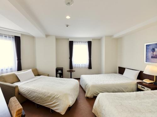 长野Hotel Courtland的酒店客房,设有两张床和一张沙发