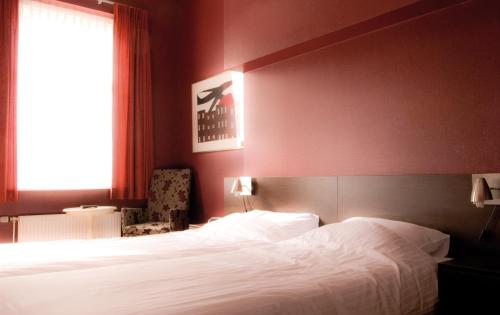 BredevoortHotel Bertram的卧室设有一张白色大床和一扇窗户。