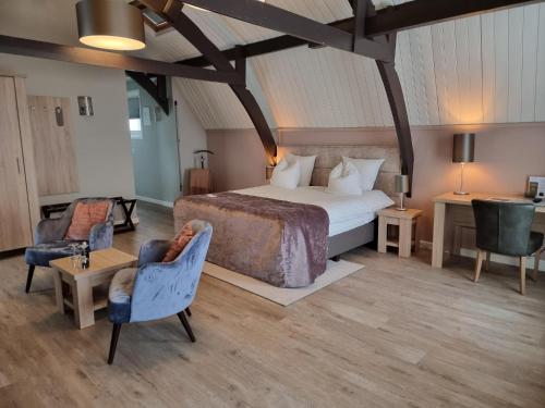 滨海卡特韦克赫伯格·维尔格勒根酒店的一间卧室配有一张床、两把椅子和一张桌子