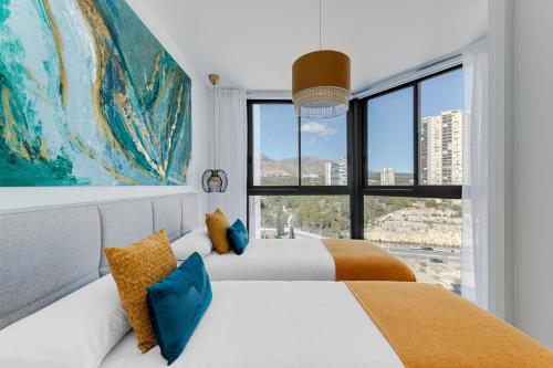 贝尼多姆SAKURA by Costa Activa Rentals的一间卧室设有两张床和大窗户