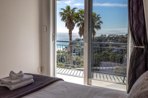 棕榈滩2 Levels of Magnificient Sea Views的一间卧室设有一张床和一个大型滑动玻璃门