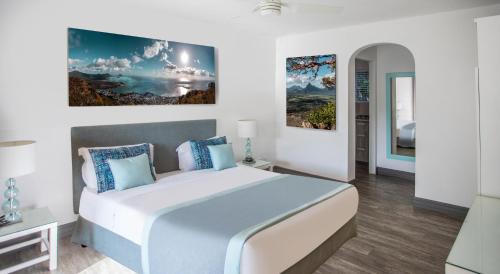 黑河区La Mariposa Mauritius的卧室配有一张大床,墙上挂有绘画作品