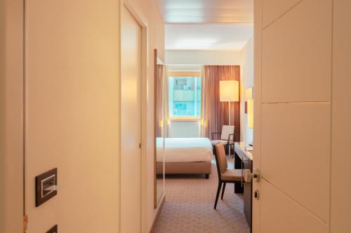 科森扎Ariha Hotel Cosenza的配有一张床和一张书桌的酒店客房