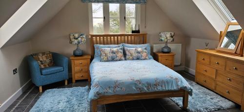 Tollard RoyalThe Hideaway的一间卧室配有一张床和一张蓝色椅子