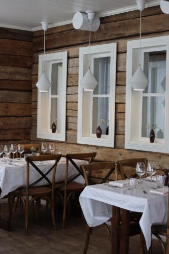 易拉斯加威奥罗拉酒店的餐厅设有白色的桌椅和窗户。